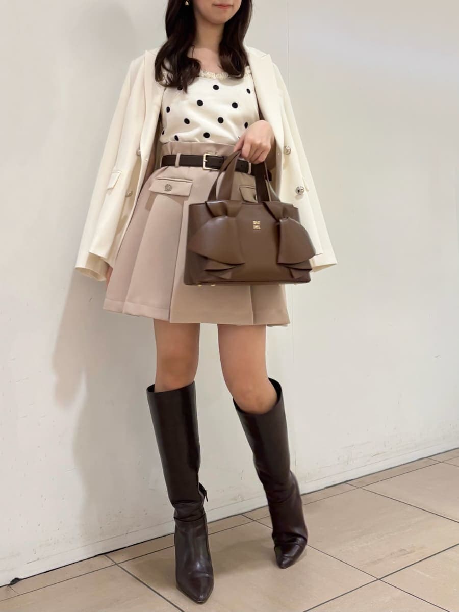 ブラウン系のブーツ、ホワイト系のテーラードジャケット、ベージュ系のスカートを着用したレディースの冬コーディネートの4枚目の写真