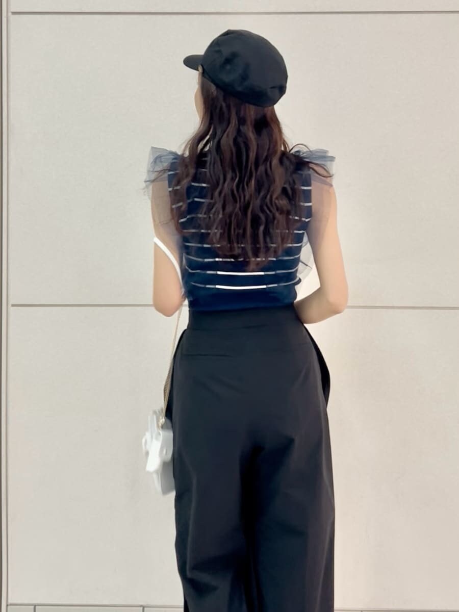 ブラック系のその他パンツ、その他のニット/セーター、ホワイト系のショルダーバッグを着用したレディースの春コーディネートの7枚目の写真