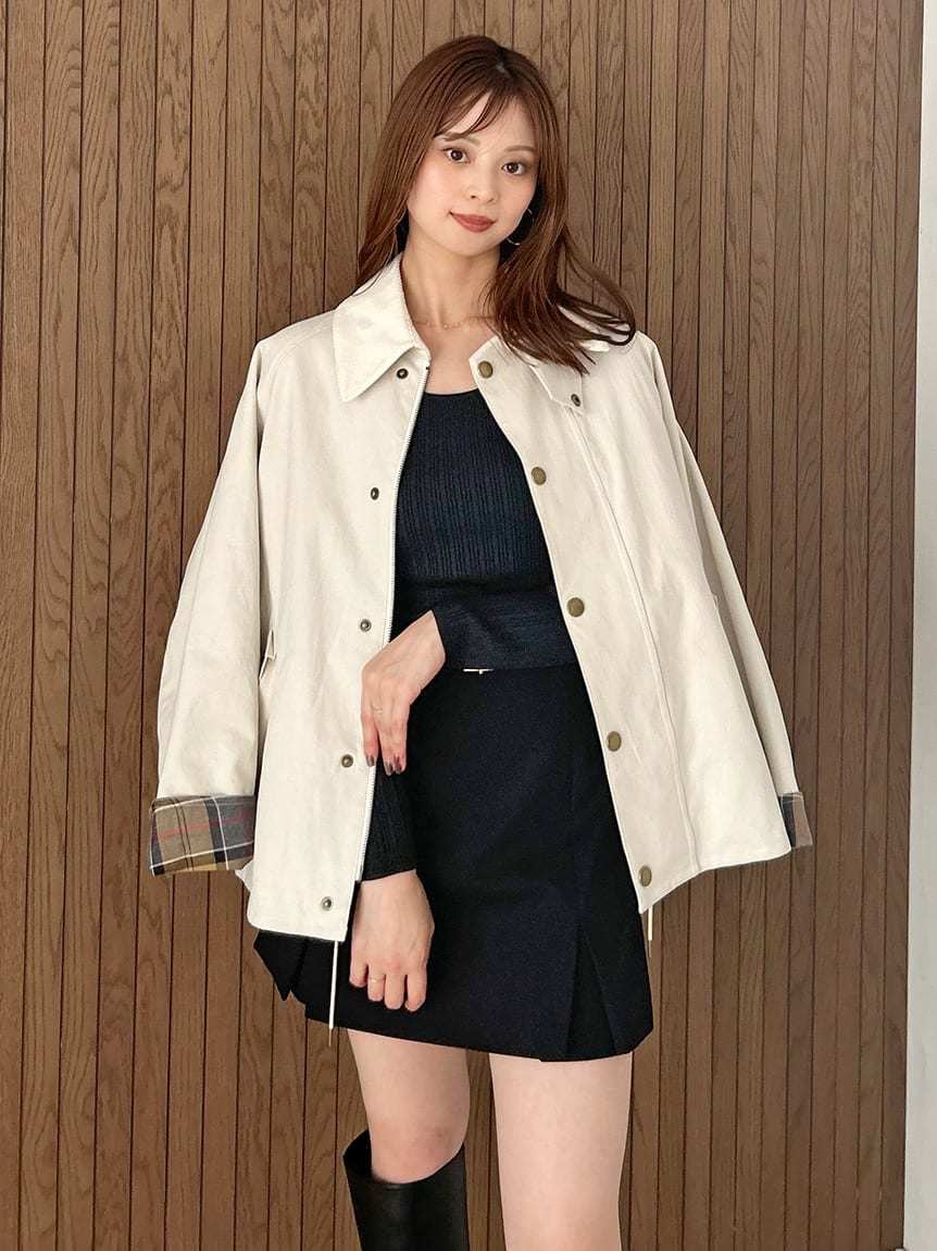 ホワイト系のブルゾン、ブラック系のスカート、ブラック系のブーツを着用したレディースの秋コーディネートの2枚目の写真