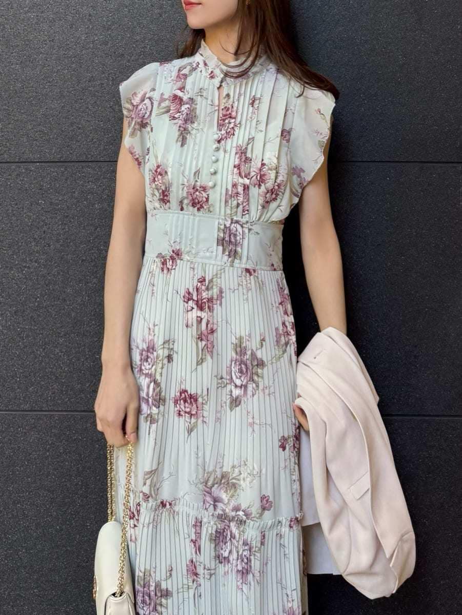 グリーン系のワンピース、ホワイト系のショルダーバッグ、ゴールド系のイヤリングを着用したレディースの春コーディネートの7枚目の写真