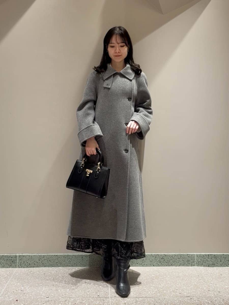 ブラック系のブーツ、グレー系のチェスターコート、ブラック系のスカートを着用したレディースの冬コーディネートの4枚目の写真
