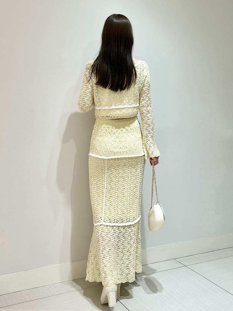イエロー系のスカート、イエロー系のニット/セーター、ホワイト系のショルダーバッグを着用したレディースの春コーディネートの5枚目の写真