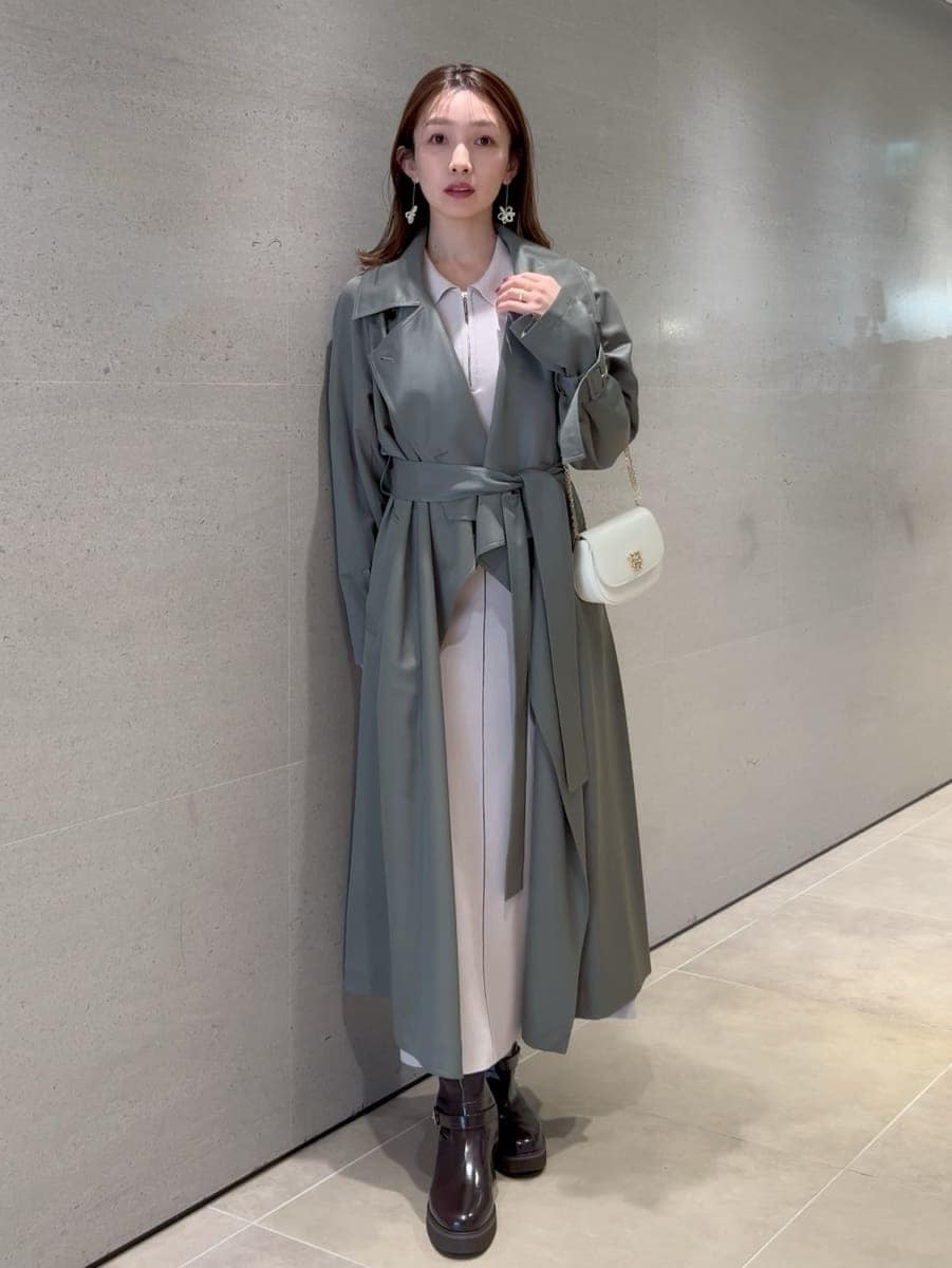 ホワイト系のワンピース、グリーン系のトレンチコート、ホワイト系のショルダーバッグを着用したレディースの冬コーディネートの9枚目の写真