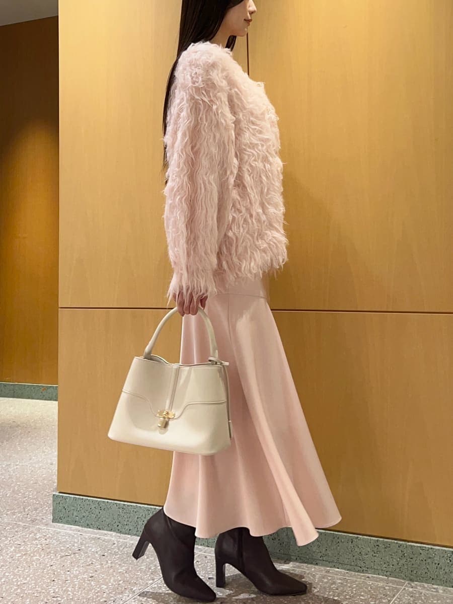 レッド系のブーツ、ピンク系のワンピース、ホワイト系のカーディガン/ボレロを着用したレディースの秋コーディネートの3枚目の写真