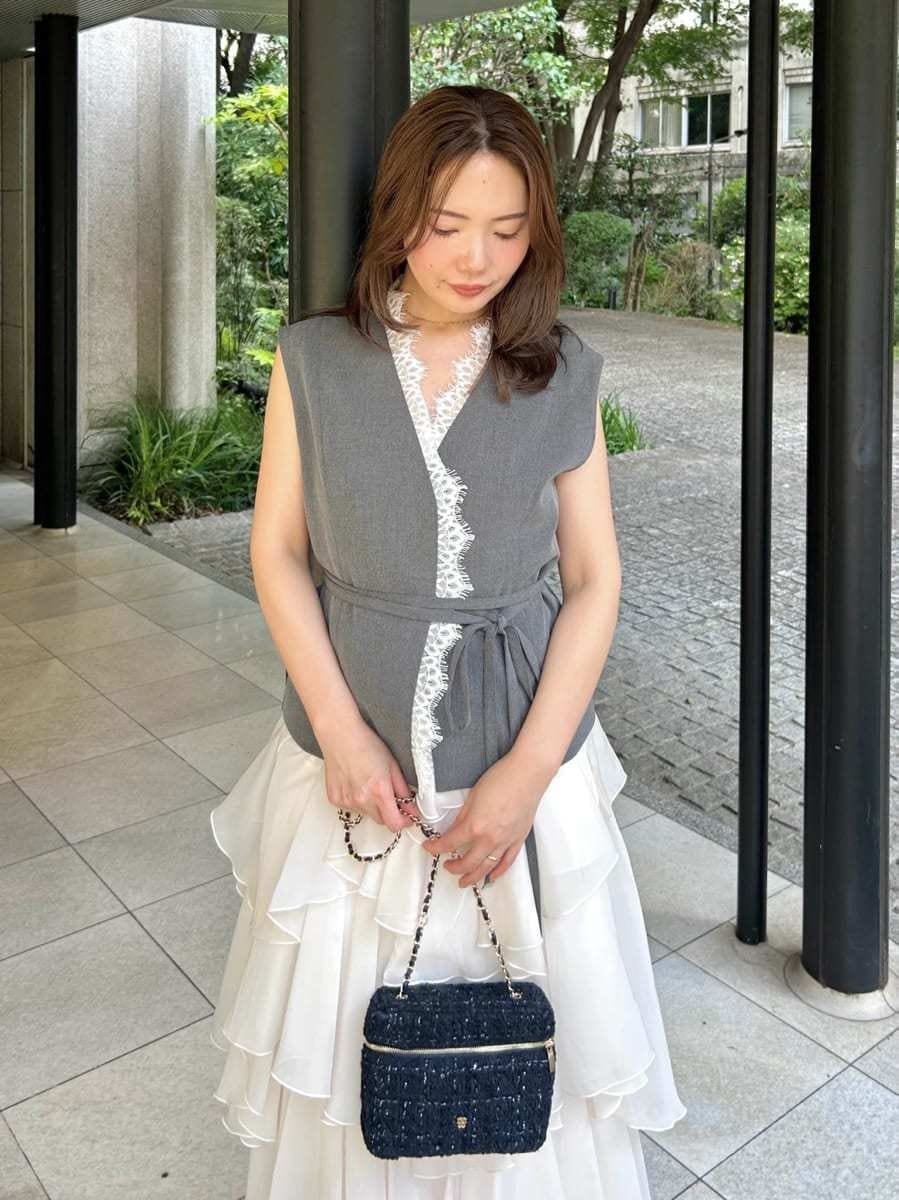 ブラック系のサンダル、グレー系のその他アウター、ホワイト系のスカートを着用したレディースの夏コーディネートの2枚目の写真