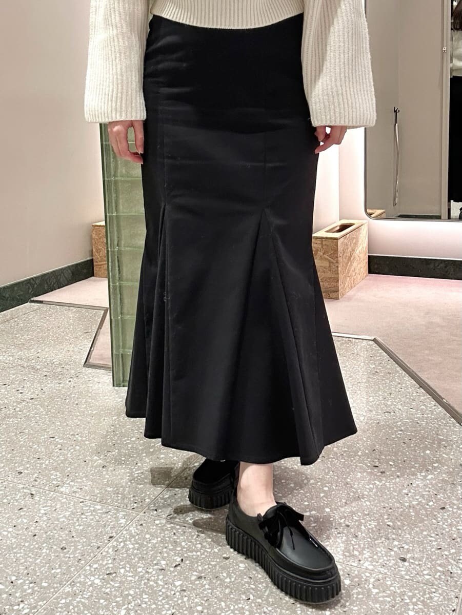 ホワイト系のニット/セーター、ブラック系のスカート、ホワイト系のハンドバッグを着用したレディースの秋コーディネートの4枚目の写真