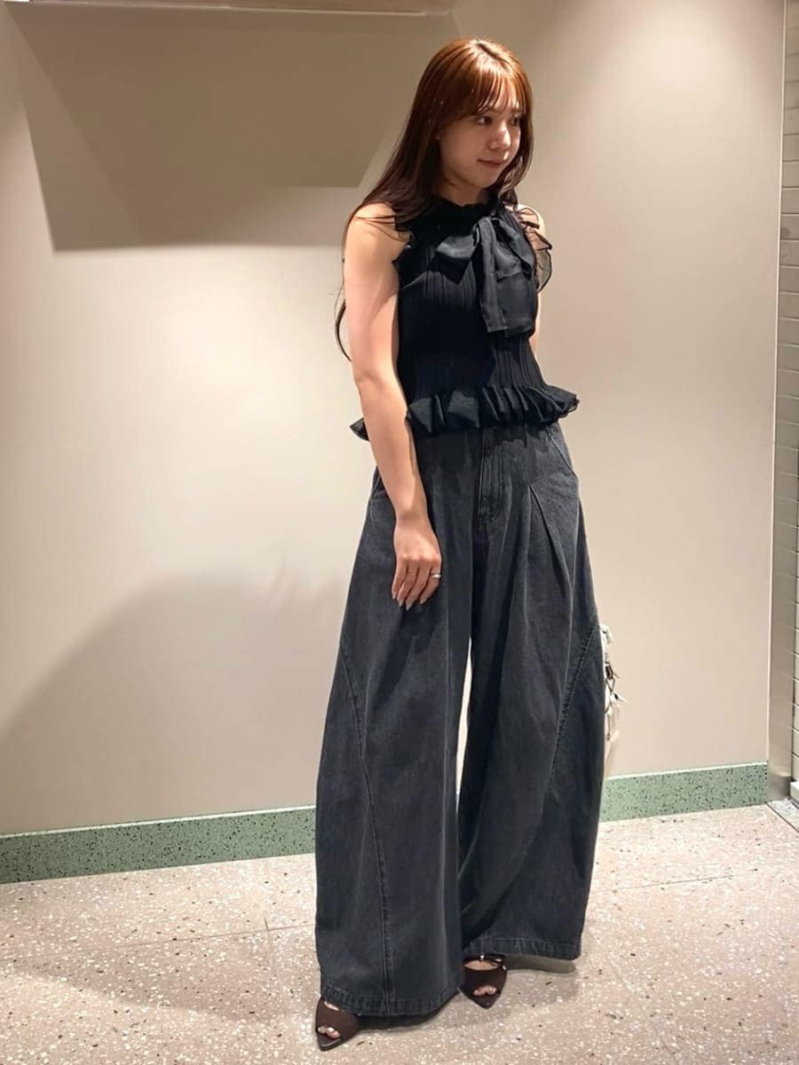 ホワイト系のショルダーバッグ、ブラック系のデニムパンツ、ブラック系のニット/セーターを着用したレディースの夏コーディネートの2枚目の写真