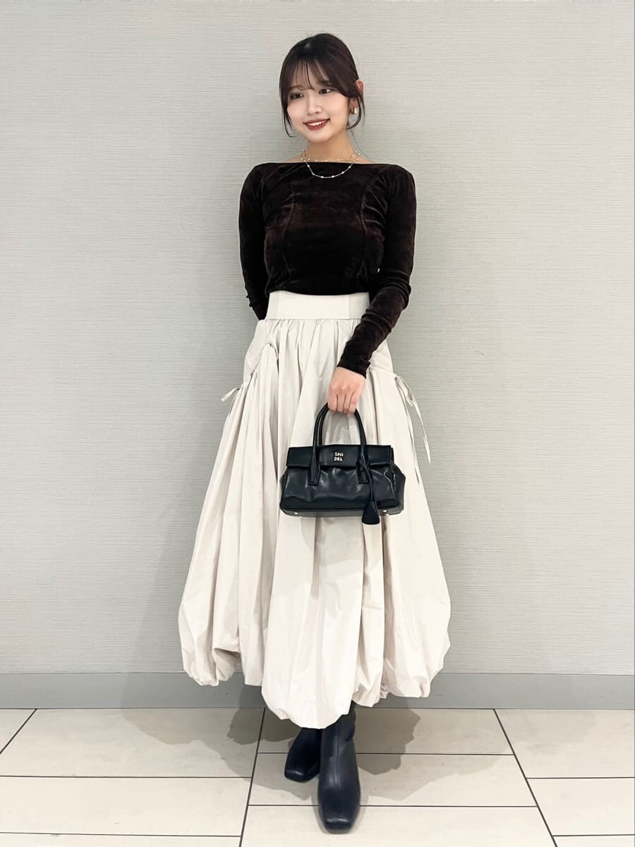 ベージュ系のスカート、ブラウン系のTシャツ/カットソー、ベージュ系のチェスターコートを着用したレディースの秋コーディネートの2枚目の写真