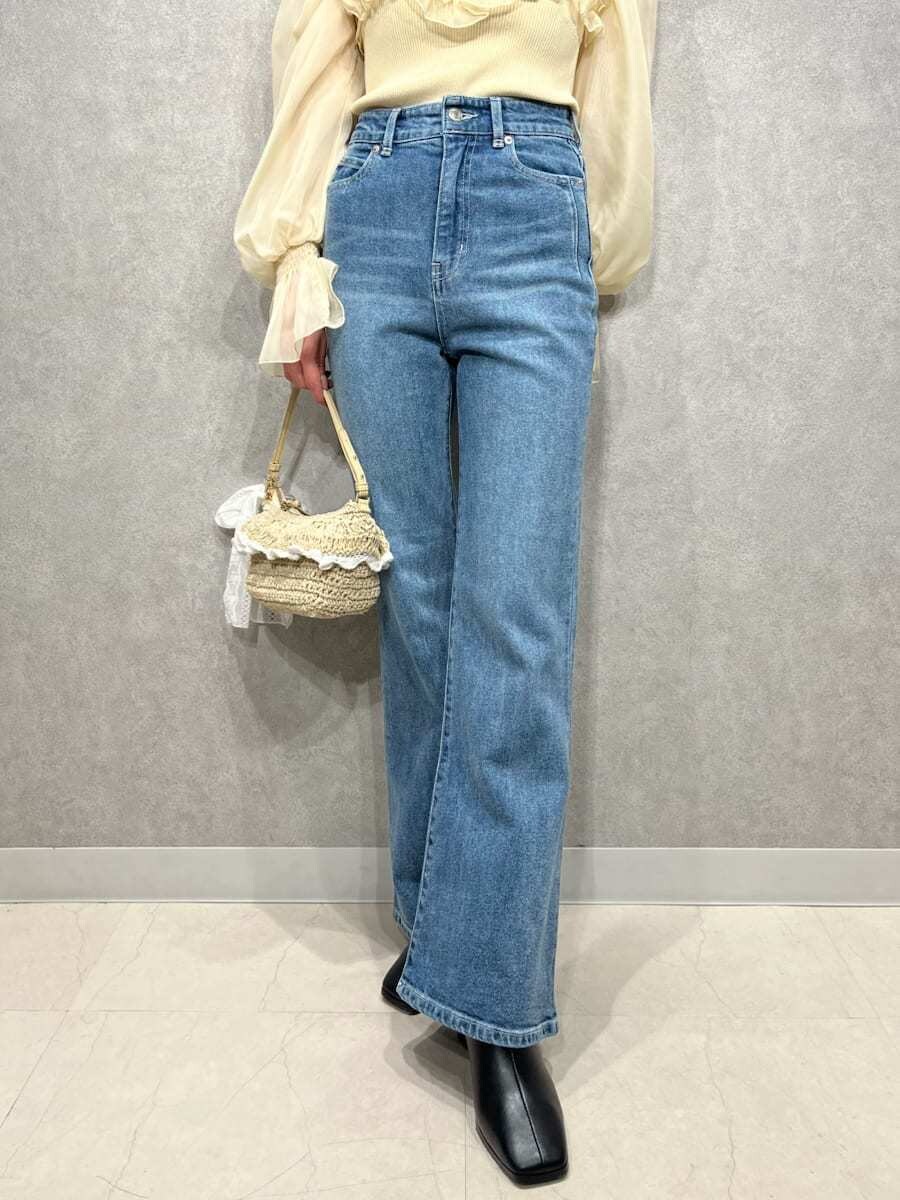 ブルー系のその他パンツ、イエロー系のニット/セーター、ホワイト系のキャップを着用したレディースの冬コーディネートの6枚目の写真