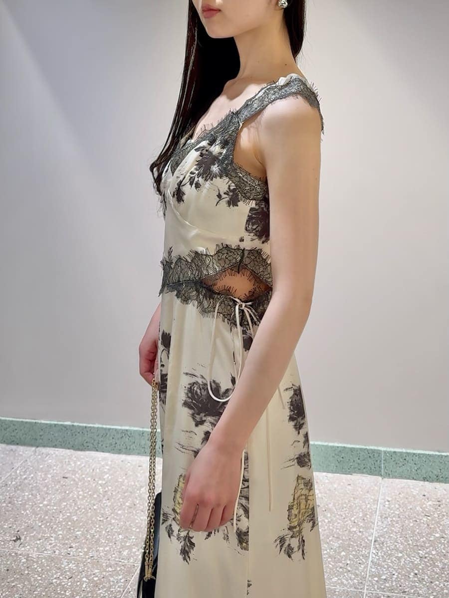 イエロー系のワンピース、ブラック系のショルダーバッグ、シルバー系のピアス（両耳用）を着用したレディースの春コーディネートの4枚目の写真