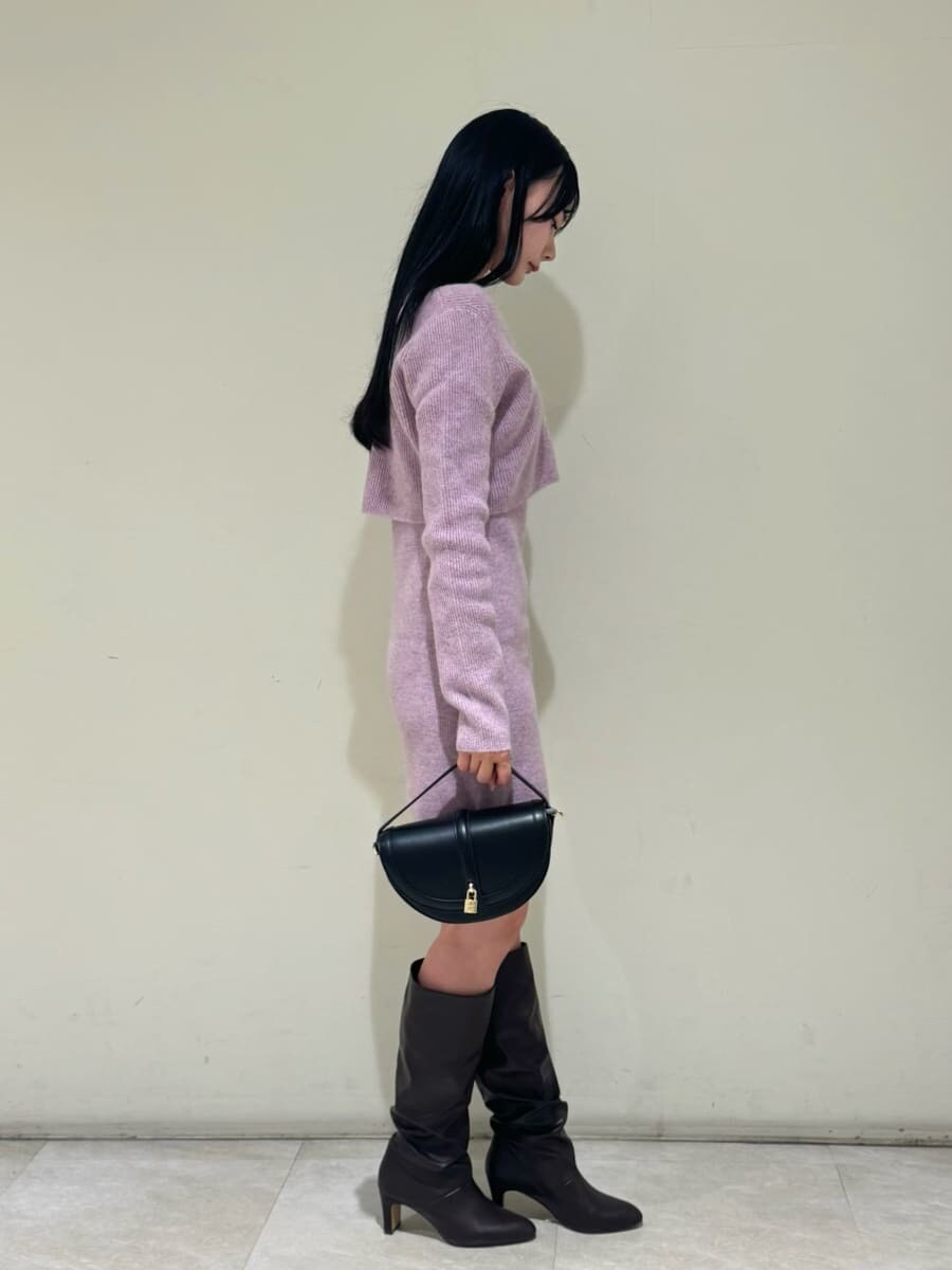 ブラック系のハンドバッグ、ピンク系のワンピース、ピンク系のカーディガン/ボレロを着用したレディースの冬コーディネートの2枚目の写真