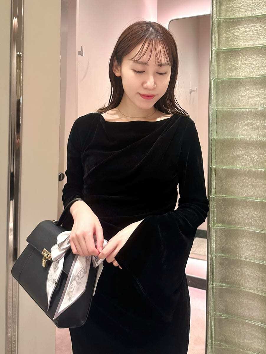 ブラック系のワンピース、ブラック系のハンドバッグを着用したレディースの秋コーディネートの2枚目の写真