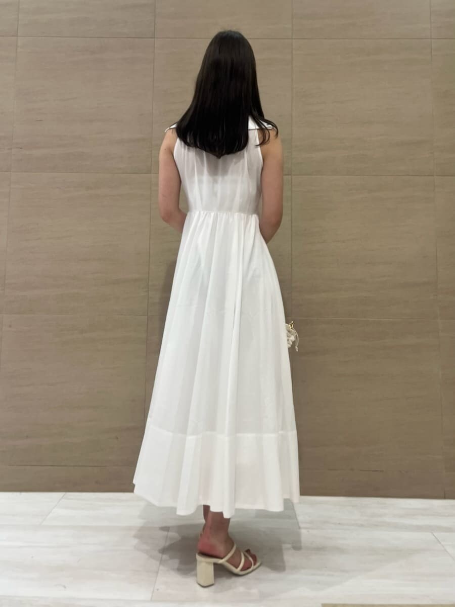 ホワイト系のワンピース、ブラウン系のかごバッグ、ホワイト系のパンプスを着用したレディースの夏コーディネートの3枚目の写真