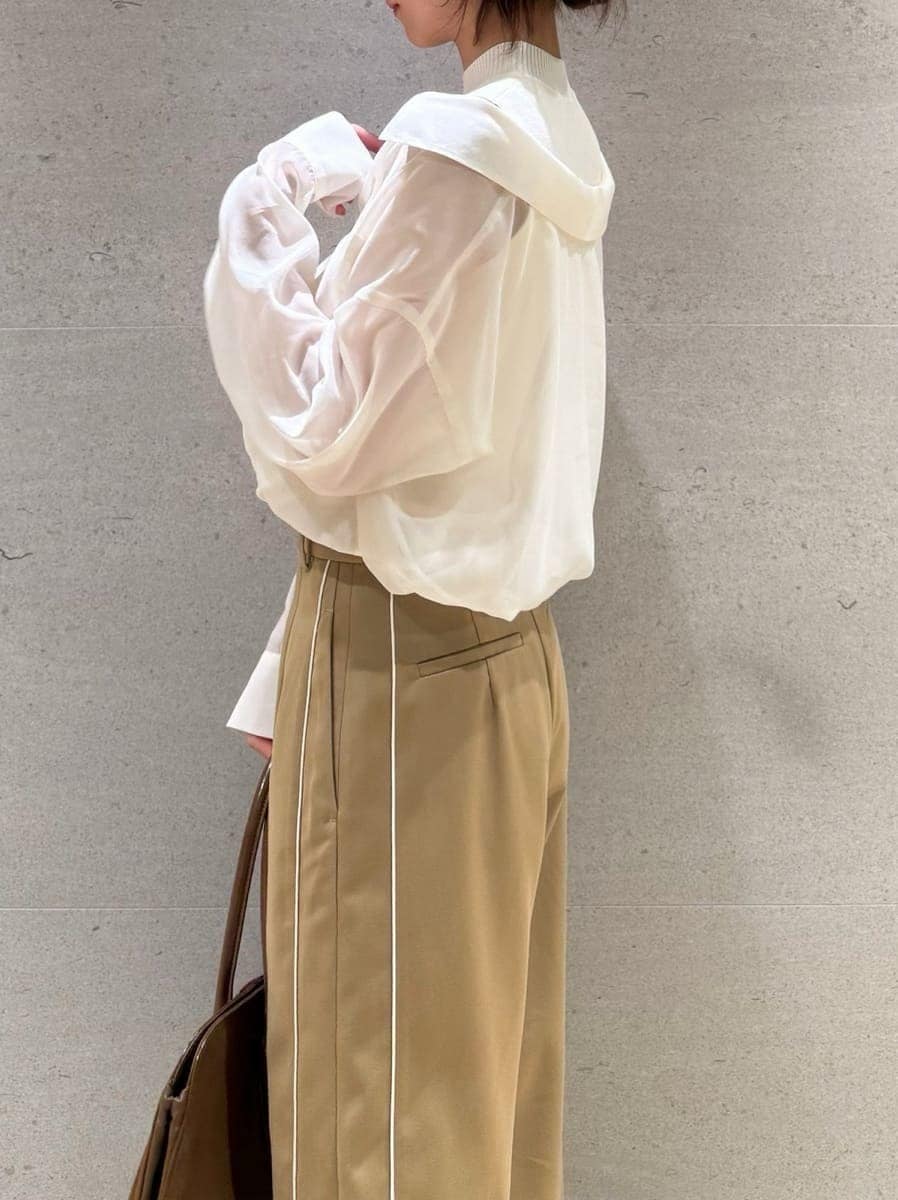 ベージュ系のその他パンツ、ホワイト系のニット/セーター、ブラウン系のハンドバッグを着用したレディースの秋コーディネートの4枚目の写真