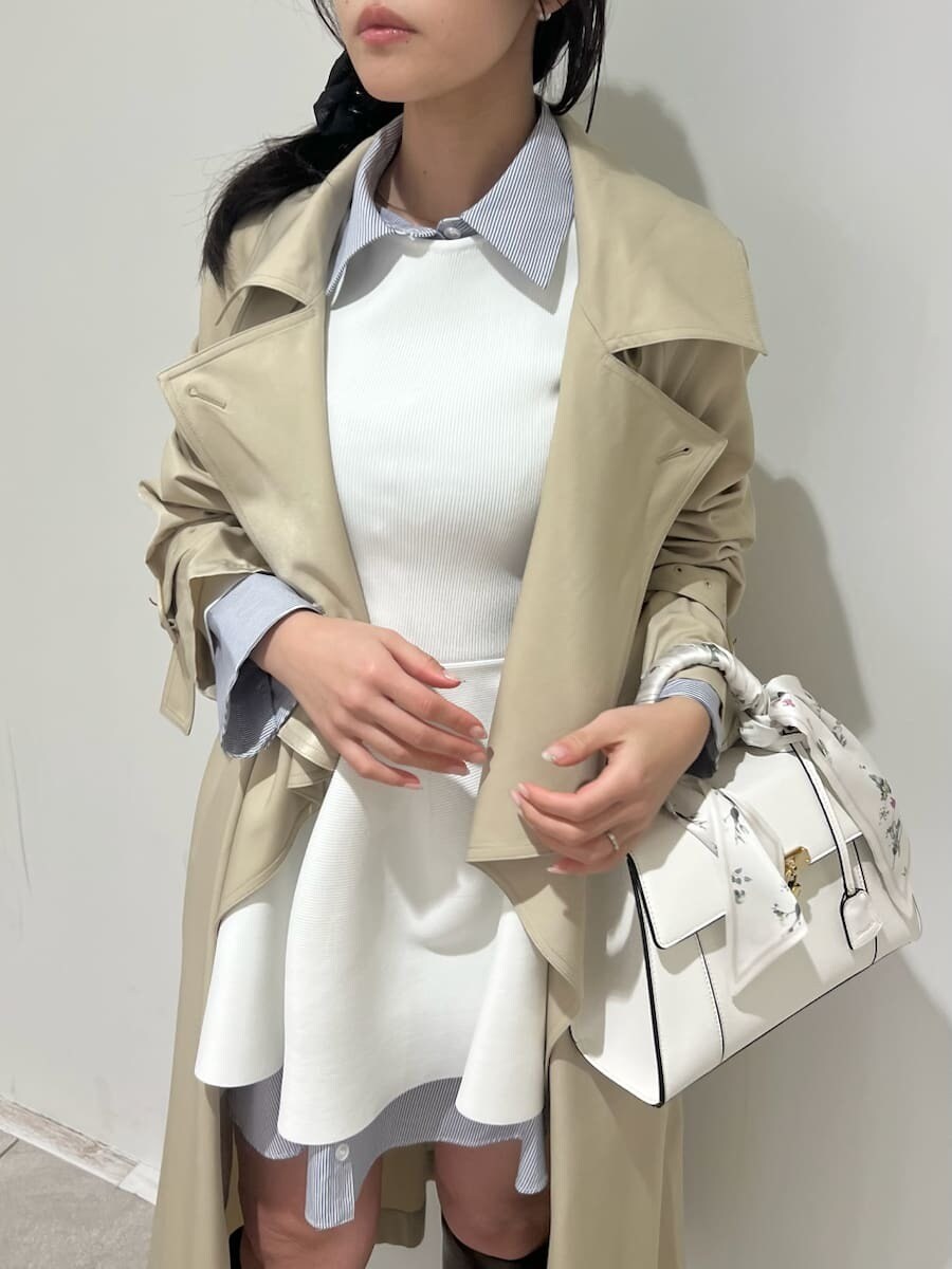 ブラウン系のブーツ、ベージュ系のトレンチコート、ホワイト系のハンドバッグを着用したレディースの冬コーディネートの9枚目の写真