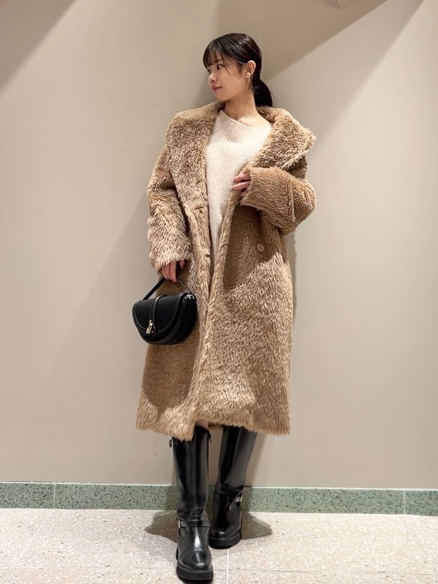 ブラック系のブーツ、ブラック系のハンドバッグ、ホワイト系のその他パンツを着用したレディースの冬コーディネートの4枚目の写真