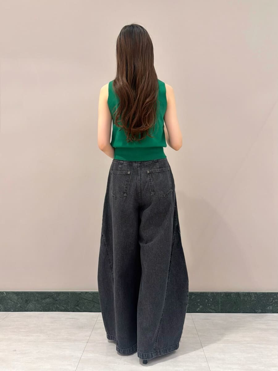 ブラック系のデニムパンツ、グリーン系のニット/セーター、ホワイト系のボストンバッグを着用したレディースの夏コーディネートの2枚目の写真