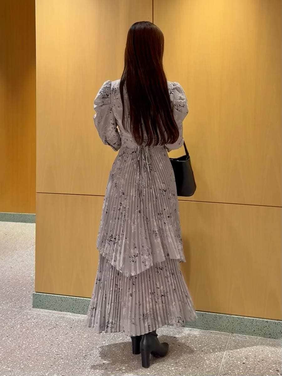 ブラック系のブーツ、グレー系のワンピース、ブラック系のハンドバッグを着用したレディースの冬コーディネートの3枚目の写真