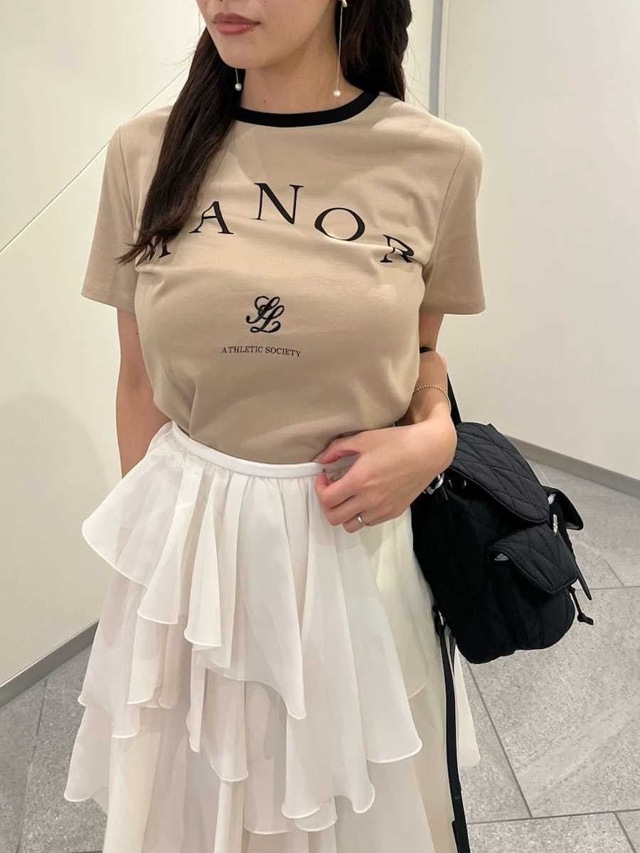 ホワイト系のスカート、ベージュ系のTシャツ/カットソー、ブラック系のサンダルを着用したレディースの夏コーディネートの3枚目の写真