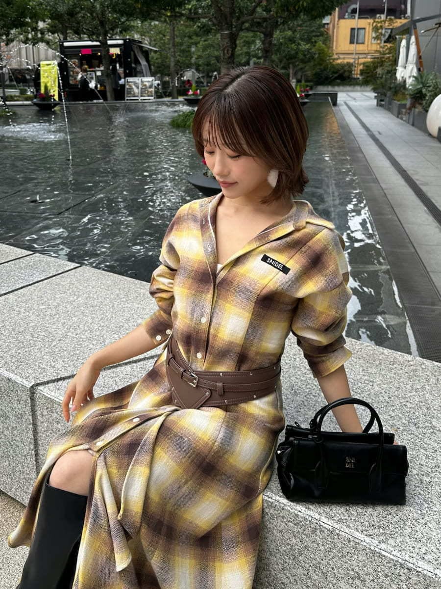 ブラック系のボストンバッグ、ホワイト系のピアス（両耳用）、ブラウン系のベルトを着用したレディースの冬コーディネートの7枚目の写真