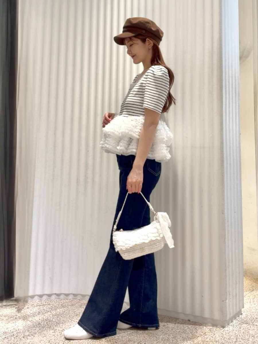 ブルー系のデニムパンツ、その他のニット/セーター、ホワイト系のパンプスを着用したレディースの春コーディネートの2枚目の写真