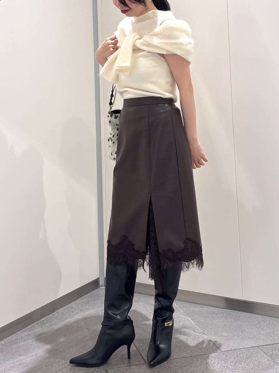 ブラウン系のスカート、ホワイト系のTシャツ/カットソー、ブラック系のブーツを着用したレディースの秋コーディネートの3枚目の写真