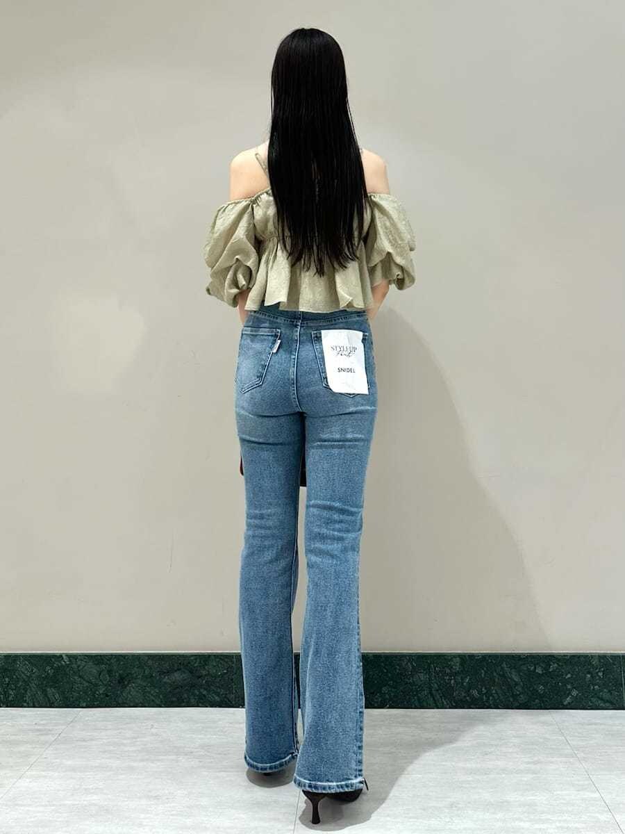 グリーン系のシャツ/ブラウス、ブルー系のその他パンツ、ブラウン系のボストンバッグを着用したレディースの夏コーディネートの3枚目の写真