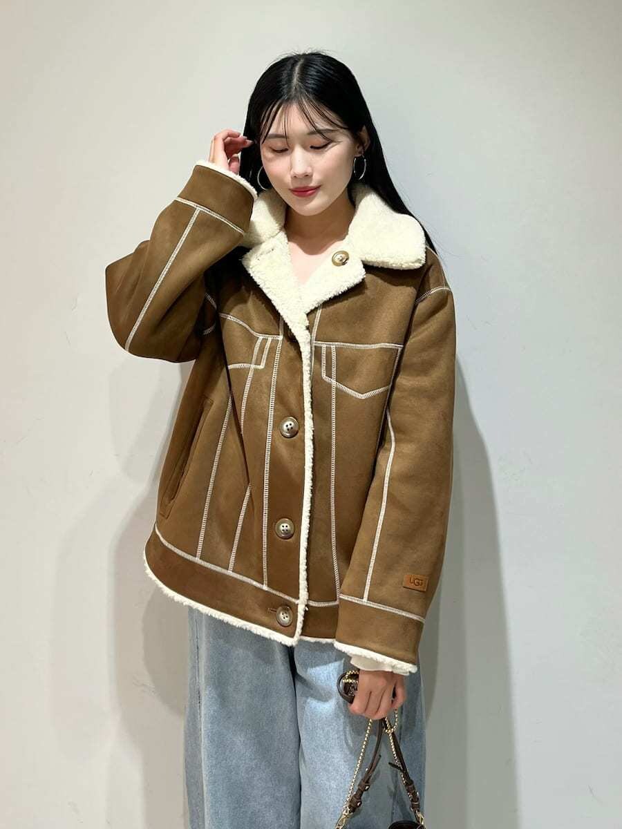 ブルー系のデニムパンツ、ブラック系のサンダル、ブラウン系のショルダーバッグを着用したレディースの秋コーディネートの5枚目の写真