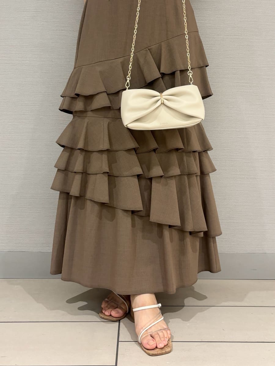 ベージュ系のスカート、ホワイト系のシャツ/ブラウス、その他のサンダルを着用したレディースの夏コーディネートの6枚目の写真