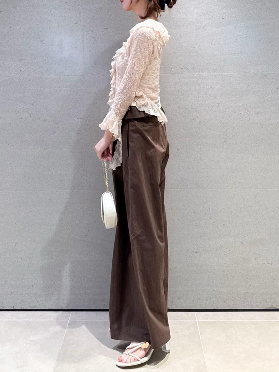 ブラウン系のその他パンツ、ピンク系のTシャツ/カットソー、ホワイト系のショルダーバッグを着用したレディースの冬コーディネートの2枚目の写真