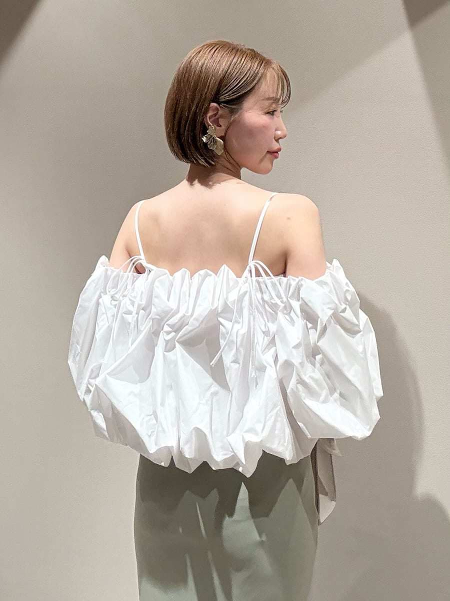 グリーン系のスカート、ホワイト系のシャツ/ブラウス、ホワイト系のハンドバッグを着用したレディースの春コーディネートの4枚目の写真