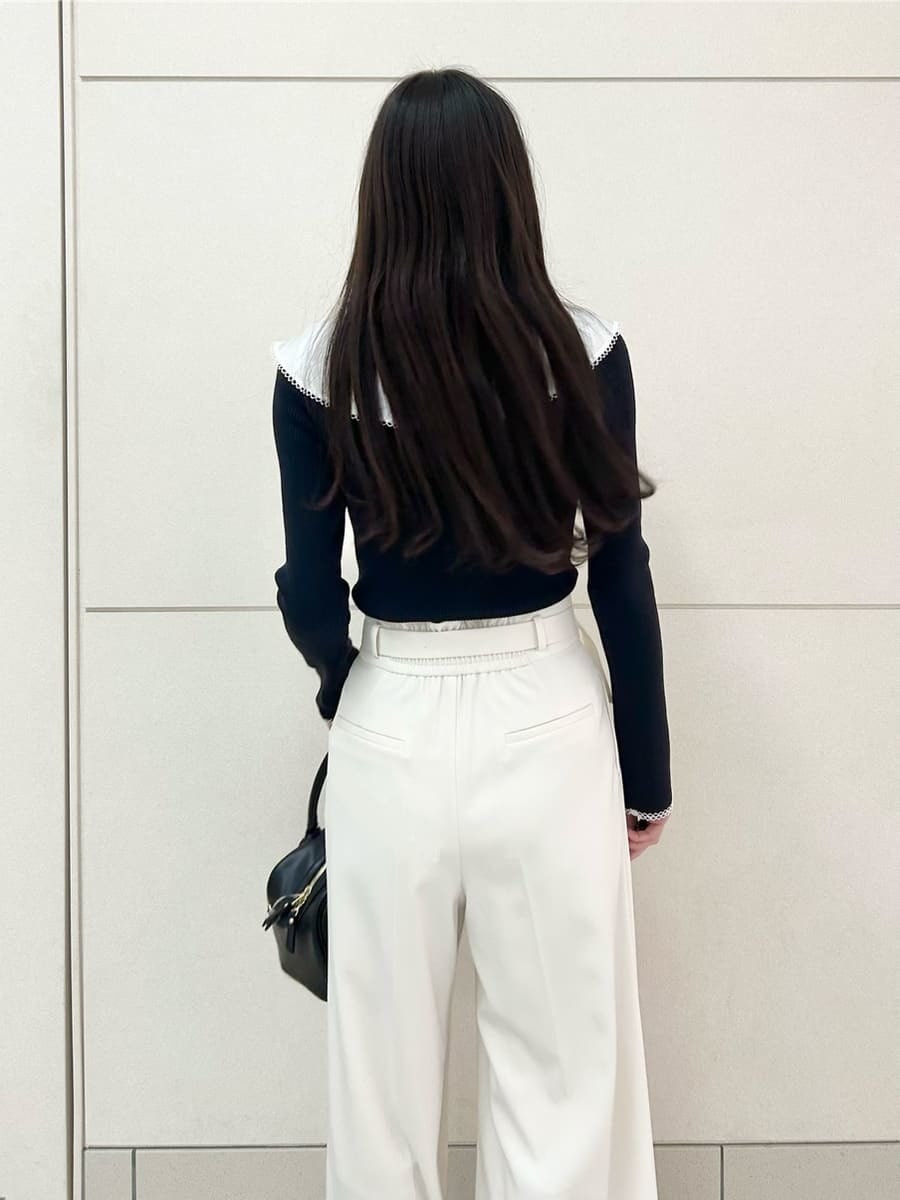 ブラック系のブーツ、ブルー系のニット/セーター、ホワイト系のその他パンツを着用したレディースの冬コーディネートの7枚目の写真