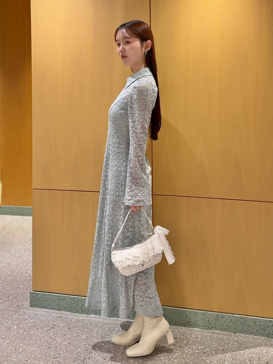 ホワイト系のブルゾン、グリーン系のワンピースを着用したレディースの冬コーディネートの4枚目の写真