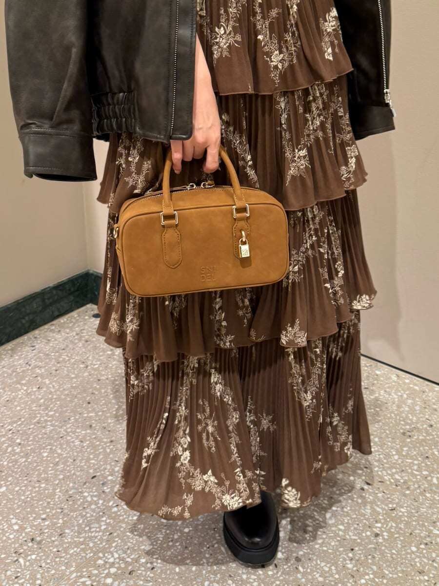 ブラウン系のワンピース、ブラウン系のブルゾン、イエロー系のボストンバッグを着用したレディースの秋コーディネートの7枚目の写真