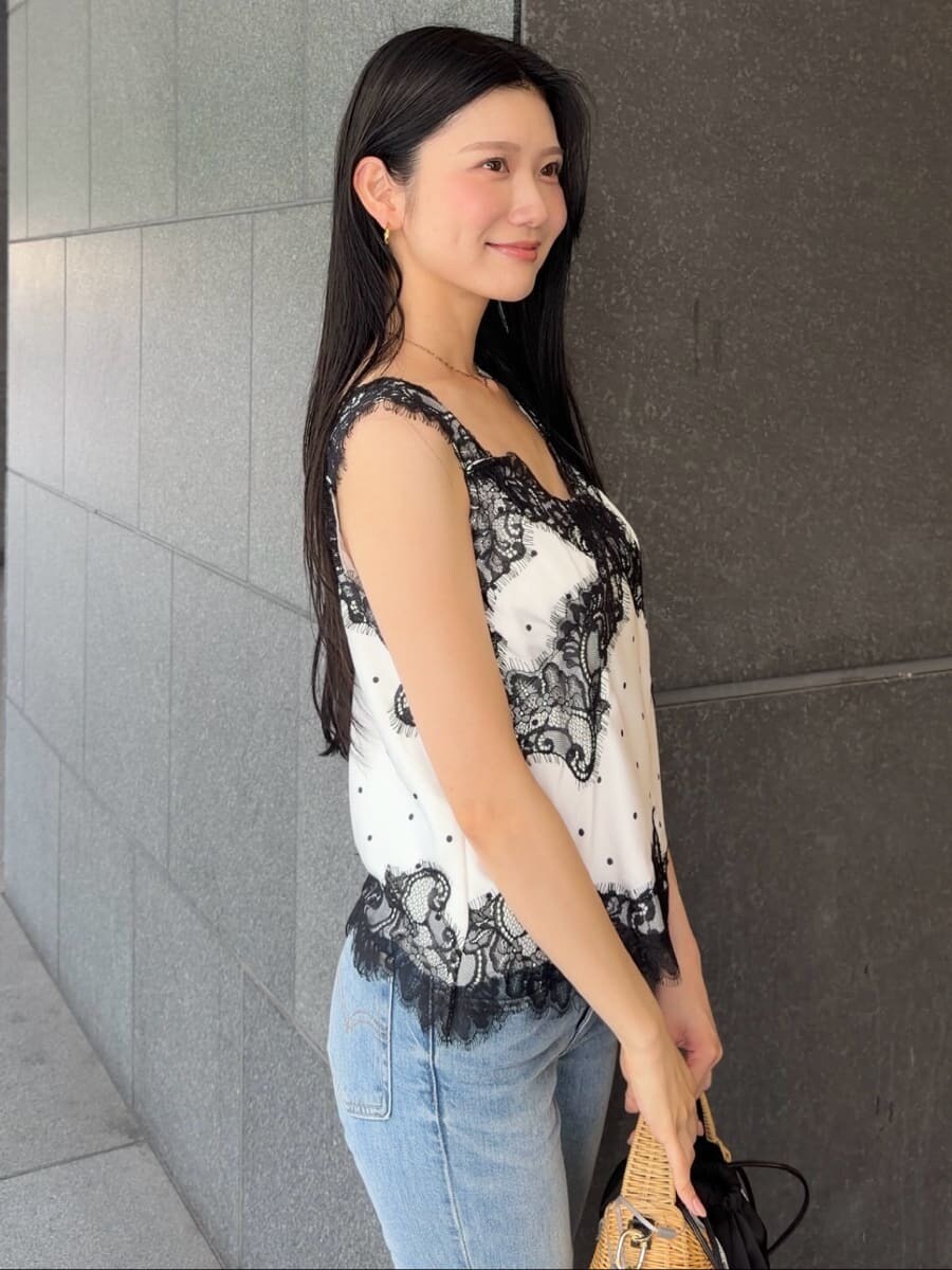 ブルー系のデニムパンツ、ブラック系のかごバッグ、その他のキャミソールを着用したレディースの夏コーディネートの6枚目の写真