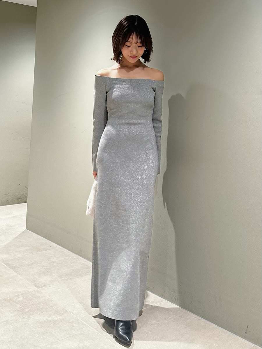 ブラック系のブーツ、シルバー系のワンピース、ホワイト系のハンドバッグを着用したレディースの冬コーディネートの6枚目の写真