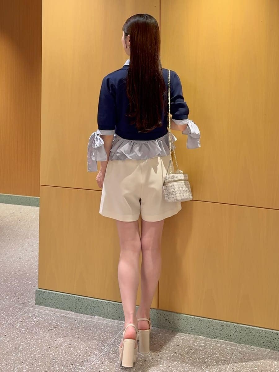 ホワイト系のその他パンツ、ブルー系のニット/セーター、ベージュ系のサンダルを着用したレディースの春コーディネートの4枚目の写真