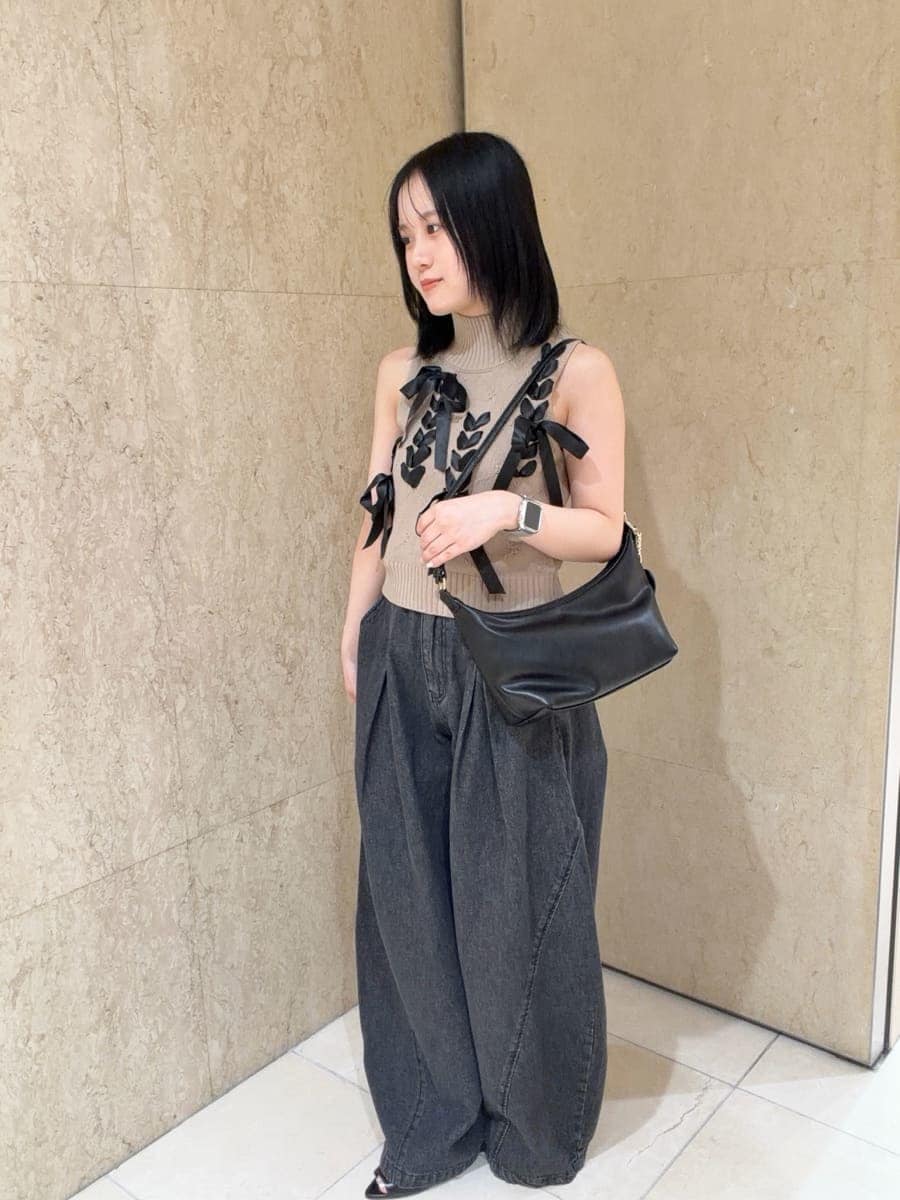 ブラック系のデニムパンツ、ベージュ系のニット/セーター、ブラック系のサンダルを着用したレディースの夏コーディネートの3枚目の写真