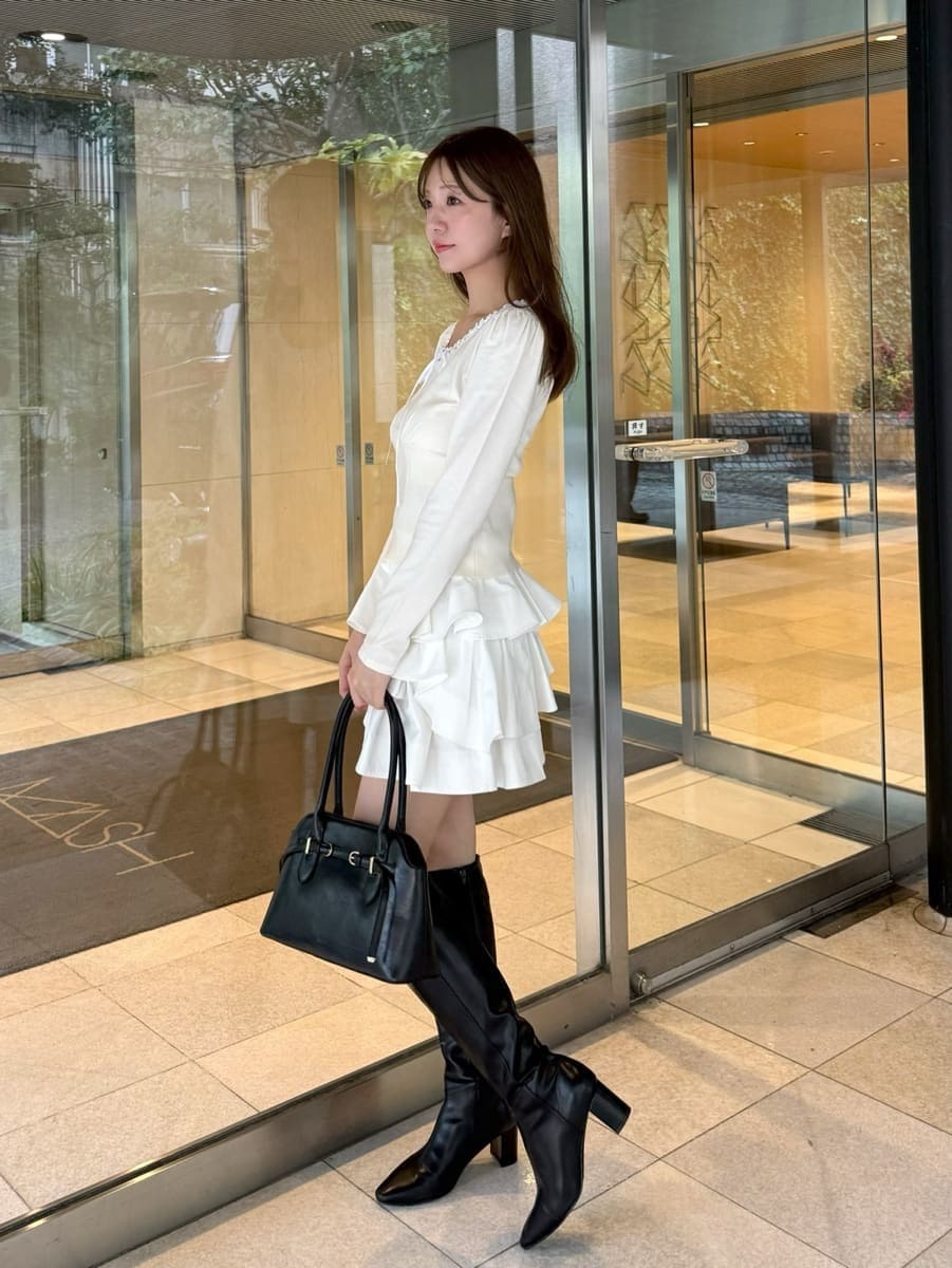 ホワイト系のその他パンツ、ホワイト系のニット/セーター、ブラック系のブーツを着用したレディースの秋コーディネートの2枚目の写真