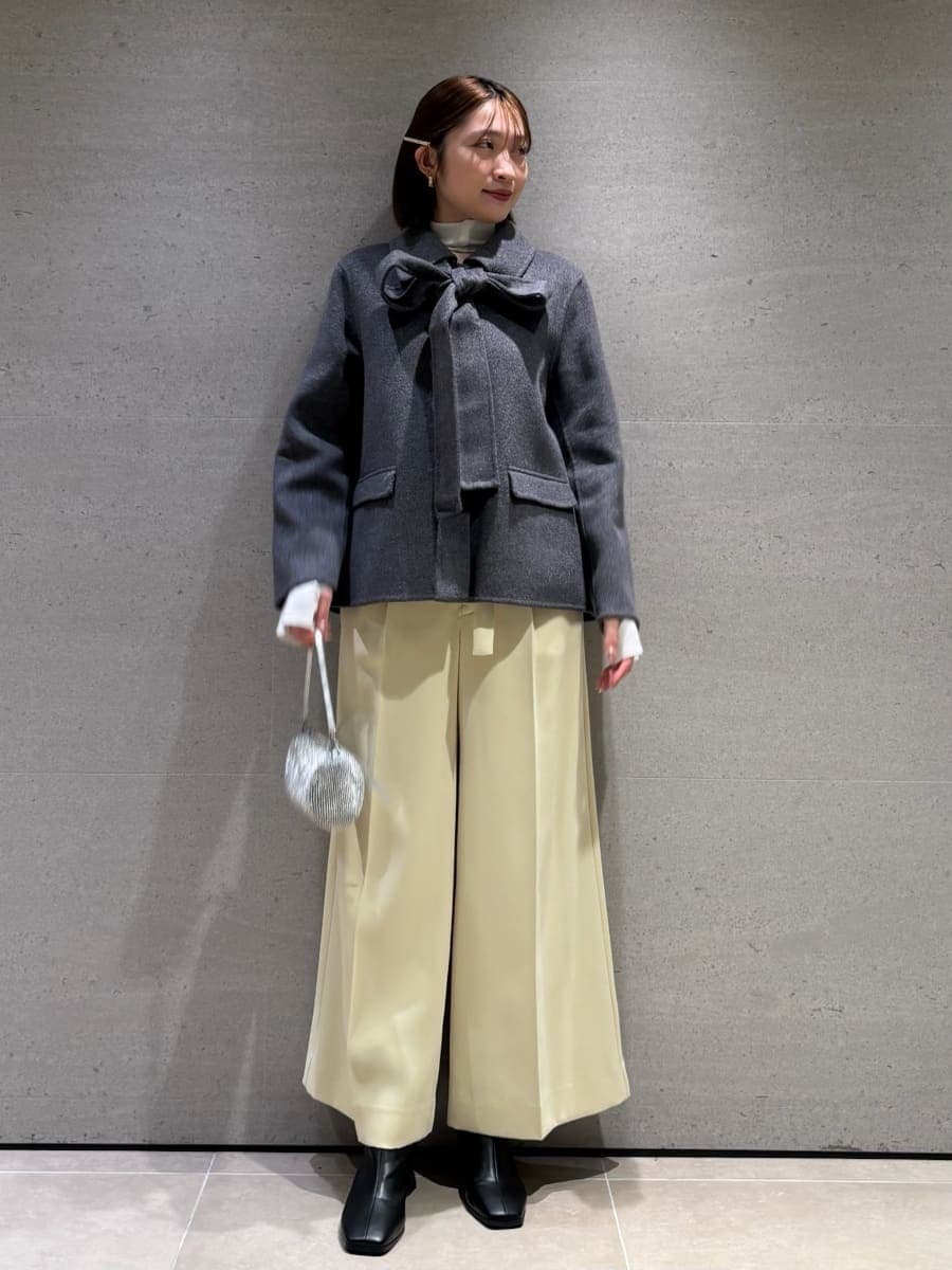 グレー系のテーラードジャケット、ホワイト系のニット/セーターを着用したレディースの秋コーディネートの2枚目の写真