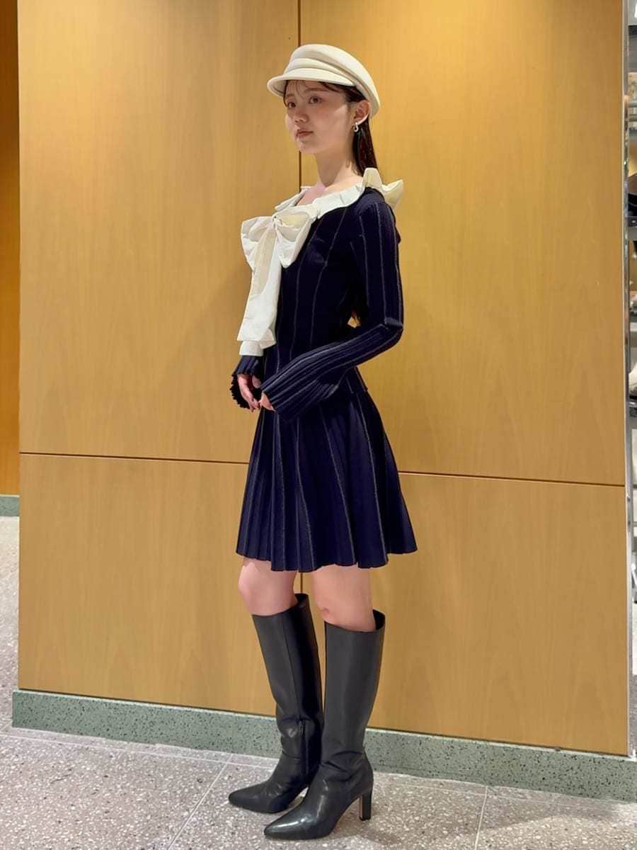 ブラック系のブーツ、ホワイト系のショルダーバッグ、ベージュ系のチェスターコートを着用したレディースの冬コーディネートの4枚目の写真