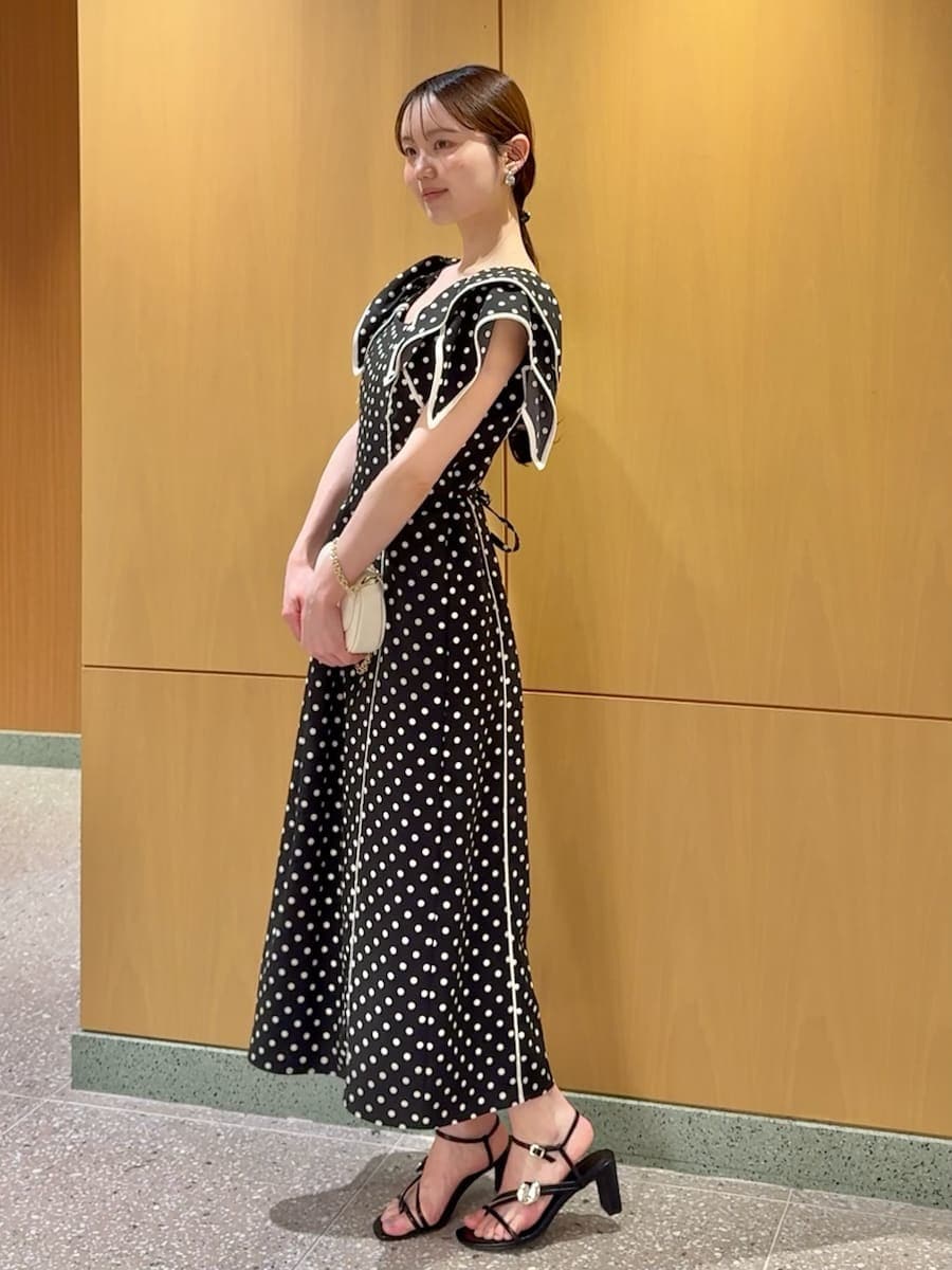 ブラック系のワンピース、ホワイト系のショルダーバッグを着用したレディースの春コーディネートの2枚目の写真