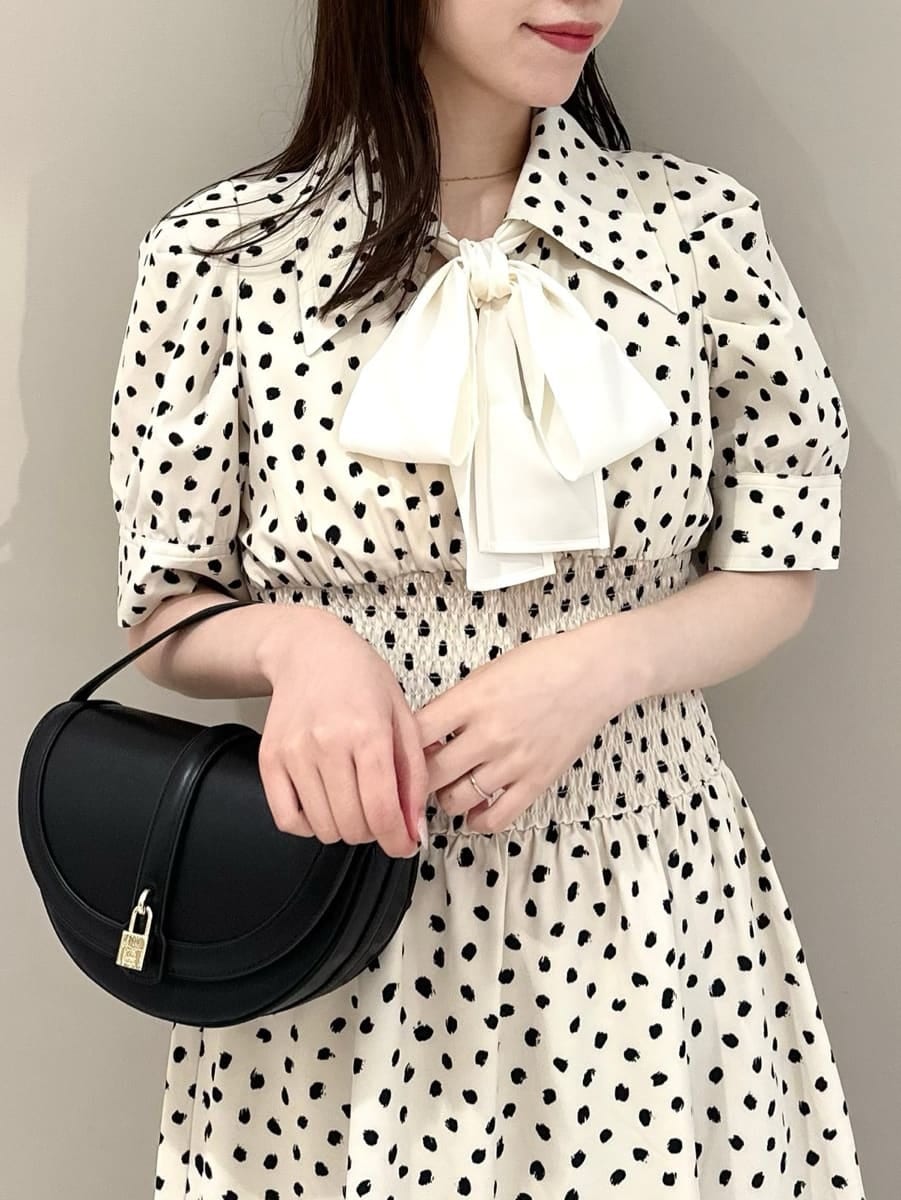 ホワイト系のワンピース、ブラック系のハンドバッグを着用したレディースの夏コーディネートの2枚目の写真