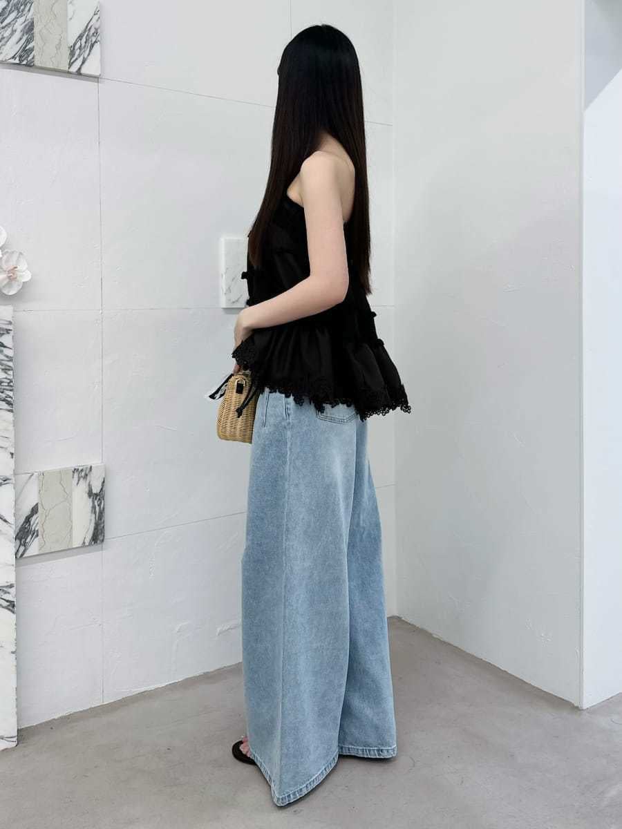 ブラック系のかごバッグ、ブルー系のデニムパンツ、ブラウン系のニット/セーターを着用したレディースの夏コーディネートの2枚目の写真