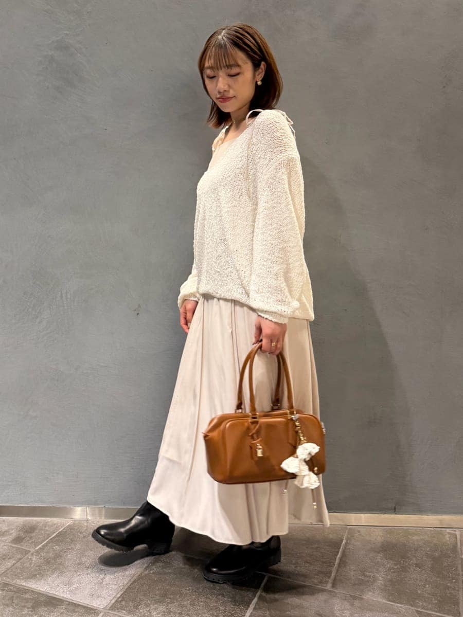 ホワイト系のワンピース、イエロー系のボストンバッグを着用したレディースの冬コーディネートの3枚目の写真