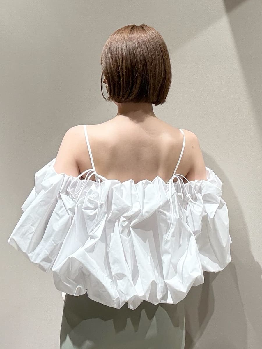 グリーン系のスカート、ホワイト系のシャツ/ブラウス、ホワイト系のハンドバッグを着用したレディースの春コーディネートの3枚目の写真