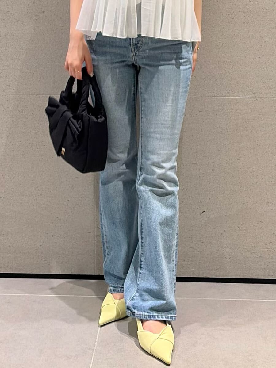 ブルー系のデニムパンツ、イエロー系のパンプス、その他のシャツ/ブラウスを着用したレディースの春コーディネートの6枚目の写真