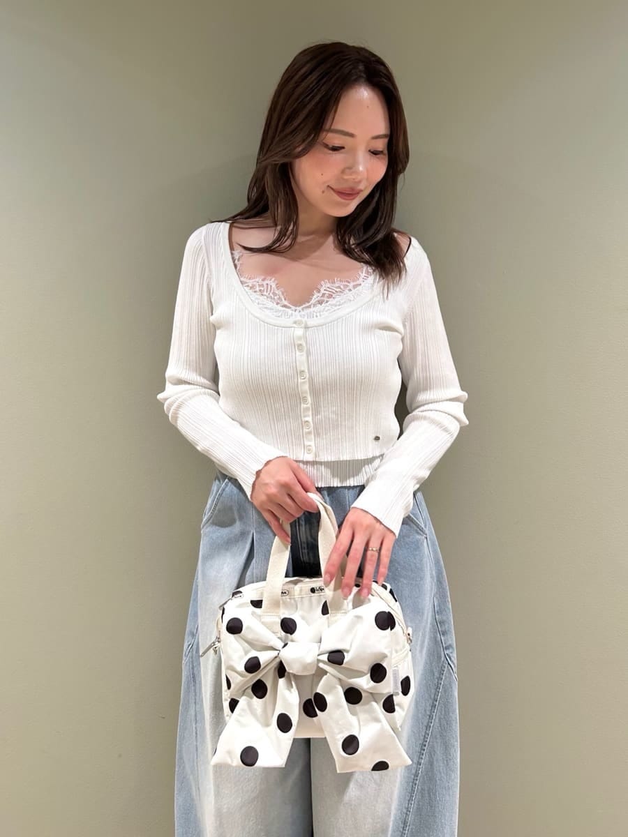 ホワイト系のニット/セーター、ホワイト系のショルダーバッグ、ブルー系のデニムパンツを着用したレディースの夏コーディネートの2枚目の写真