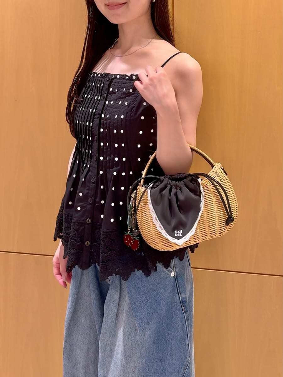 ブラック系のかごバッグ、ブルー系のデニムパンツ、その他のキャミソールを着用したレディースの夏コーディネートの6枚目の写真