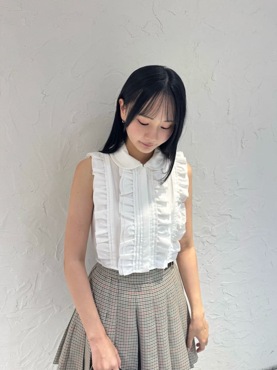 ホワイト系のシャツ/ブラウス、ベージュ系のスカート、ブラック系のブーツを着用したレディースの夏コーディネートの5枚目の写真